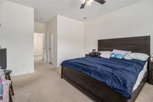 a room with a bed and ceiling fan