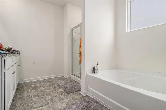 a spacious bathroom with bathtub and shower