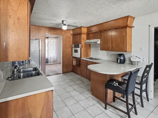 a kitchen with a sink a stove and cabinets