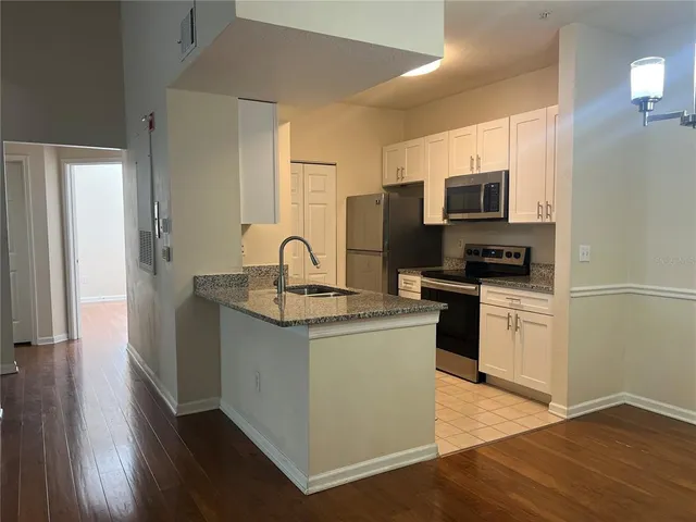 a kitchen with a sink a microwave a refrigerator and cabinets