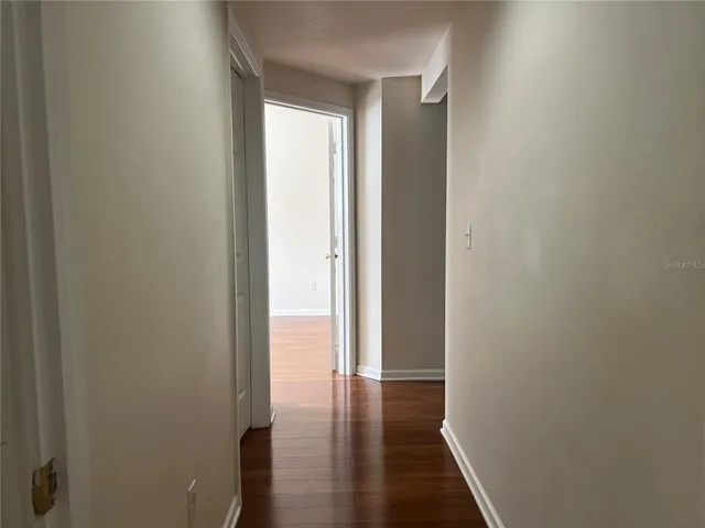 a view of a hallway with wooden floor