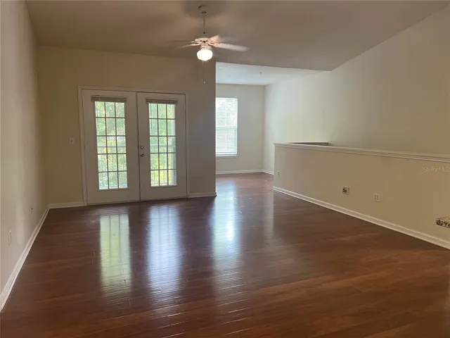 an empty room with wooden floor and windows