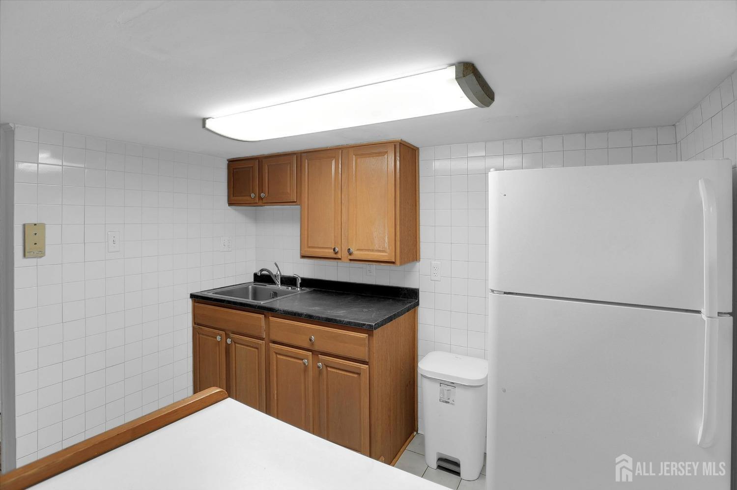 434 Ridge Road Dayton, NJ 08810 - Photo 16 of 46 a kitchen with a sink a refrigerator and cabinets