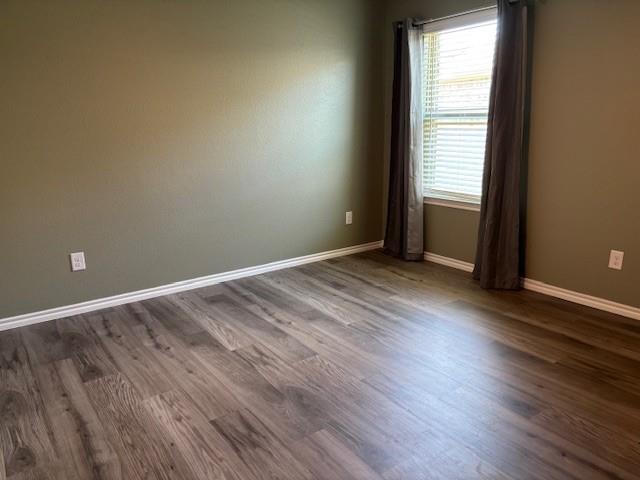 515 Rustic Meadows Trail Princeton, TX 75407 - Photo 21 of 29 a view of an empty room with wooden floor and a window