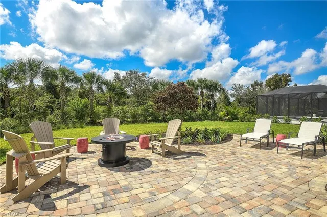 a view of a patio with a dining table and chairs with wooden fence