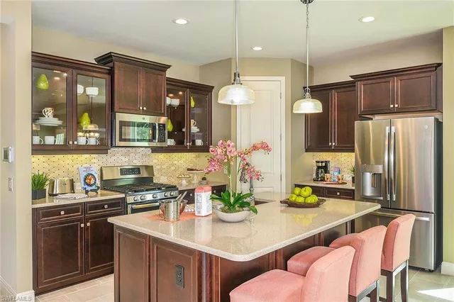 a kitchen with stainless steel appliances a sink a stove a refrigerator and cabinets