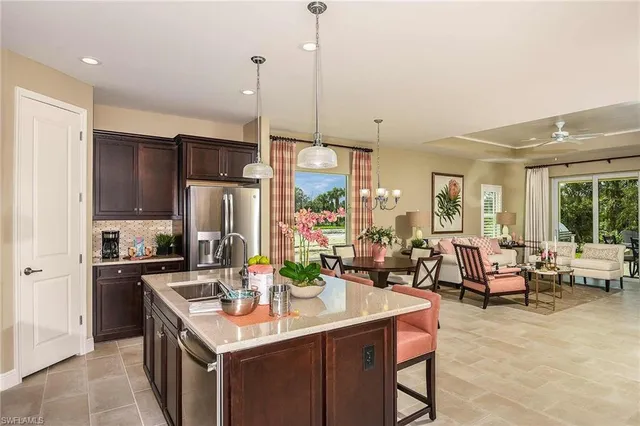 a kitchen with kitchen island a large counter top space a sink stainless steel appliances and cabinets