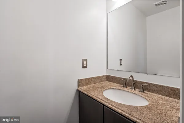 a bathroom with a granite countertop sink and a mirror