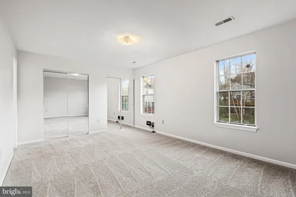 an empty room with windows and closet