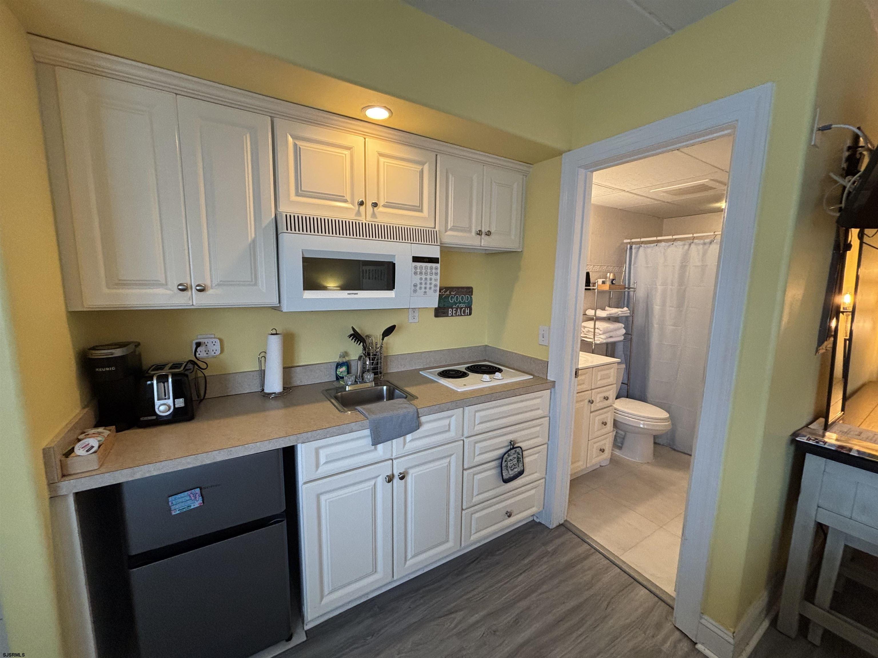 900 Wesley Avenue, Unit 210 Ocean City, NJ 08226 - Photo 11 of 16 a kitchen with a sink a stove and cabinets