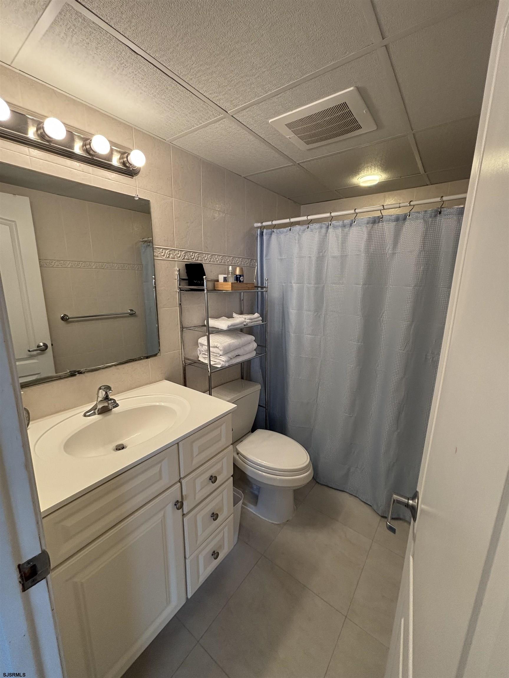 900 Wesley Avenue, Unit 210 Ocean City, NJ 08226 - Photo 13 of 16 a view of bathroom with a sink mirror vanity and toilet