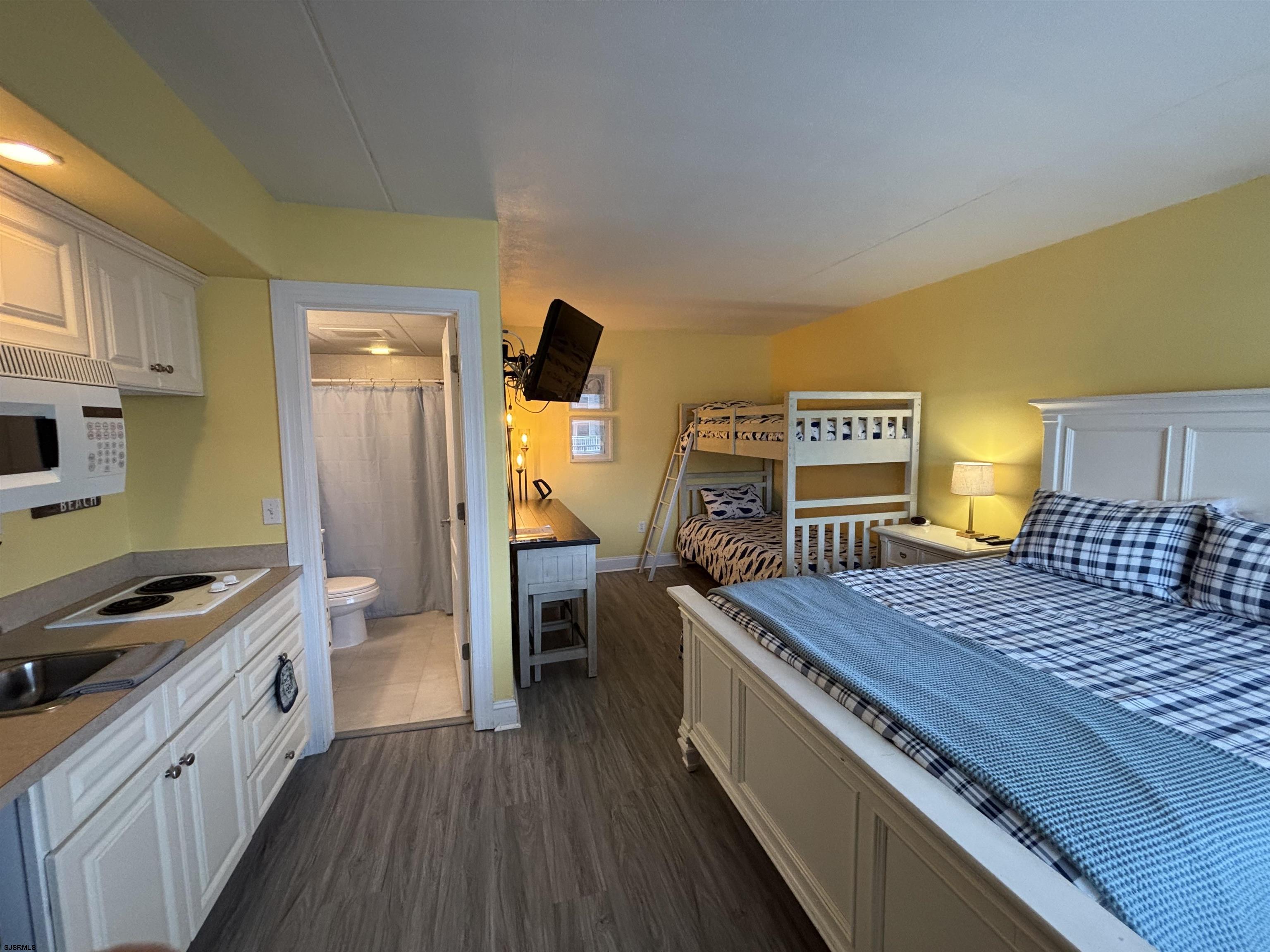 900 Wesley Avenue, Unit 210 Ocean City, NJ 08226 - Photo 7 of 16 a bed room with a bed and a television