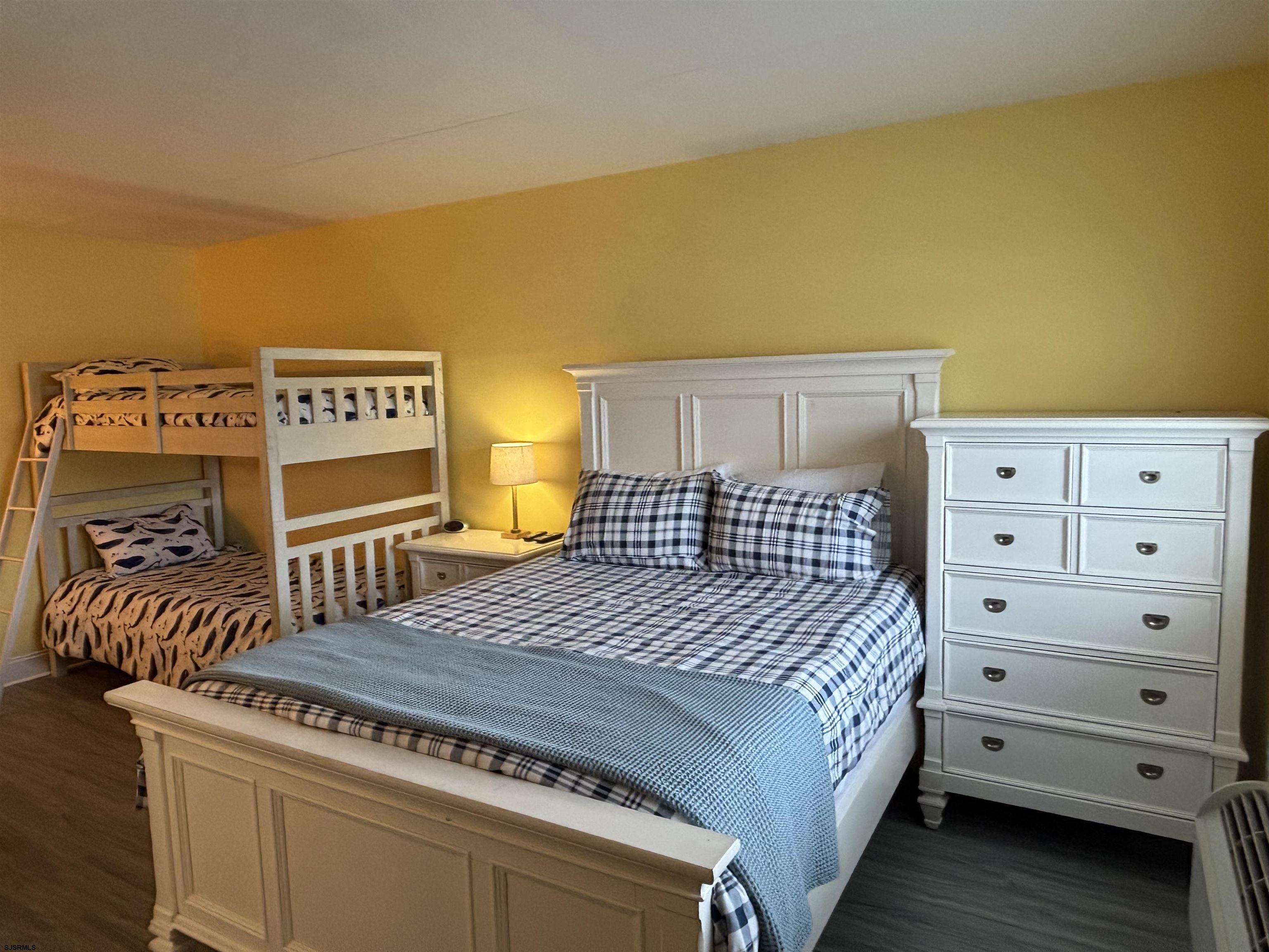 900 Wesley Avenue, Unit 210 Ocean City, NJ 08226 - Photo 9 of 16 a bed room with a bed and a dresser