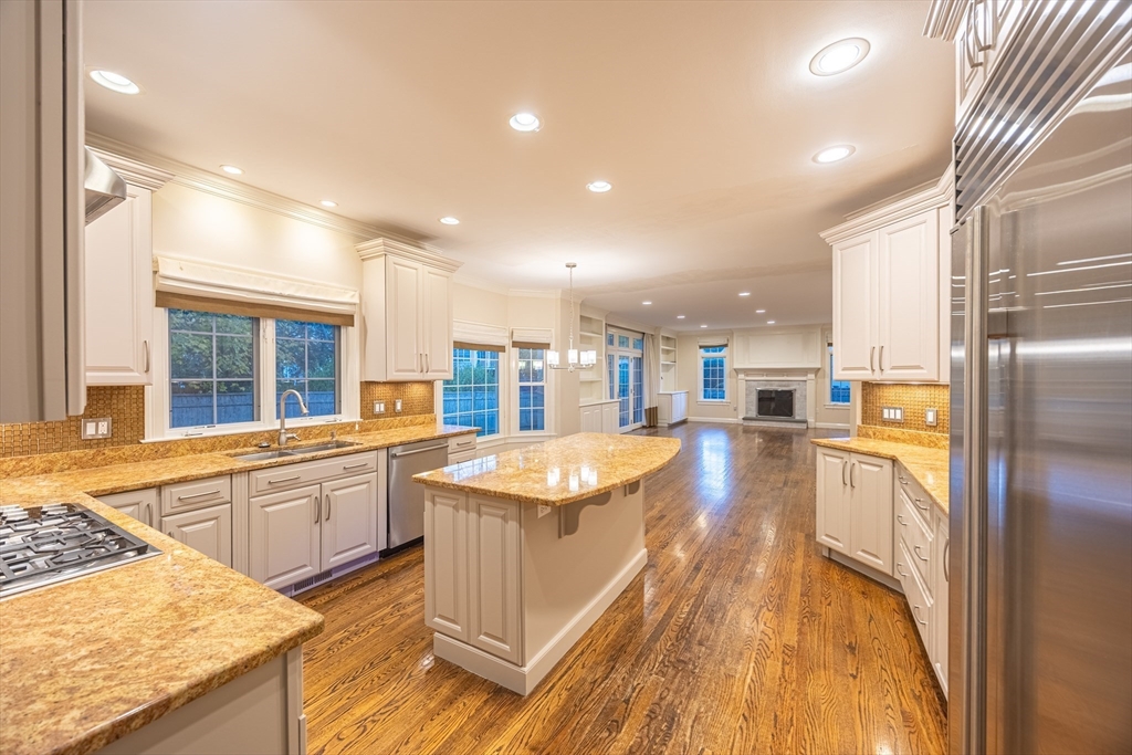 27 Mellon Road Wellesley, MA 02482 - Photo 4 of 42 a large kitchen with kitchen island a large counter top and stainless steel appliances