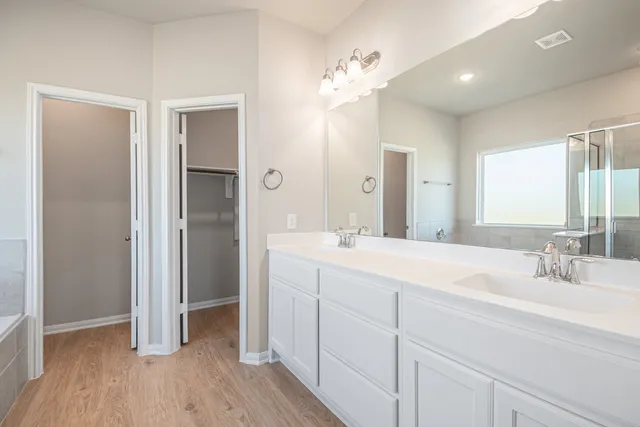 a bathroom with a double vanity sink and mirror