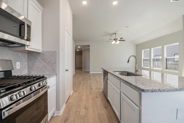 a kitchen with granite countertop a stove and a sink