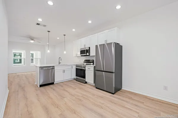a kitchen with a refrigerator and a stove top oven