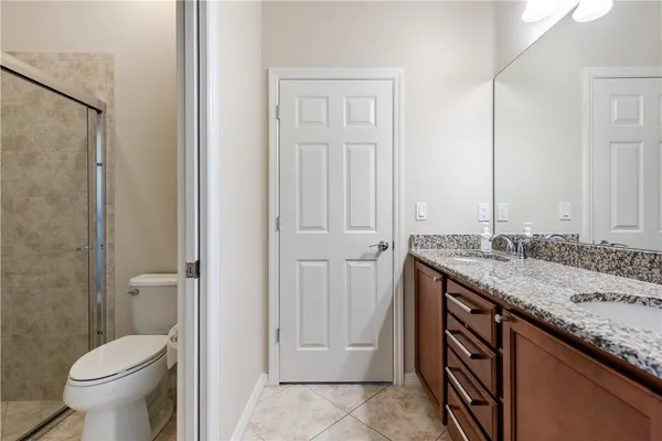 a bathroom with a granite countertop sink and a toilet