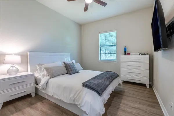 a bedroom with a bed and a flat tv screen on dresser