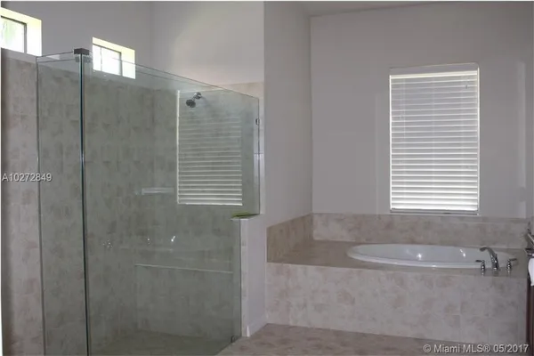 a bathroom with shower bathtub and window