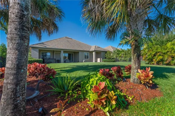 a view of swimming pool with outdoor seating and trees in the background