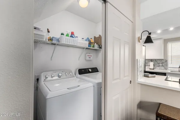 a view of washer and dryer with kitchen in the background