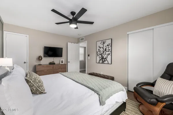 a bedroom with a large bed and a flat screen tv