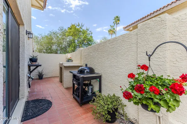 a backyard of a house with wooden floor and flowers
