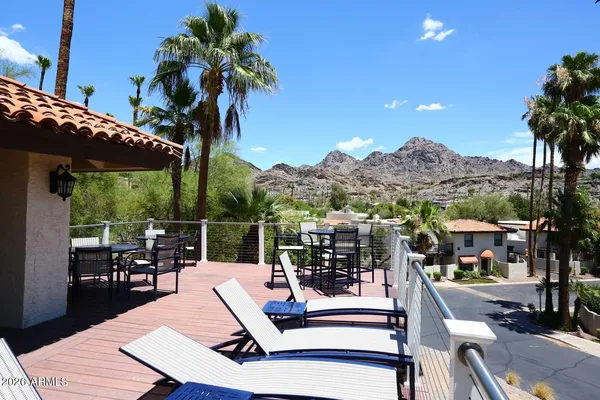 a view of a patio with couches table and chairs potted plants and palm tree