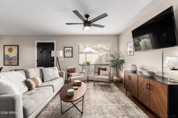 a living room with furniture ceiling fan and a flat screen tv
