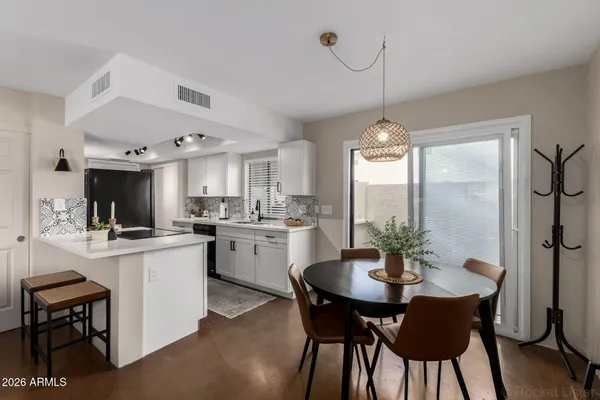 a kitchen with a dining table chairs stainless steel appliances and cabinets