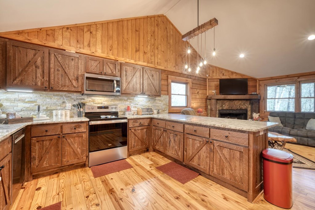 450 Mull Valley Road Morganton, GA 30560 - Photo 3 of 36 a kitchen with stainless steel appliances granite countertop a sink wooden cabinets and a view of living room