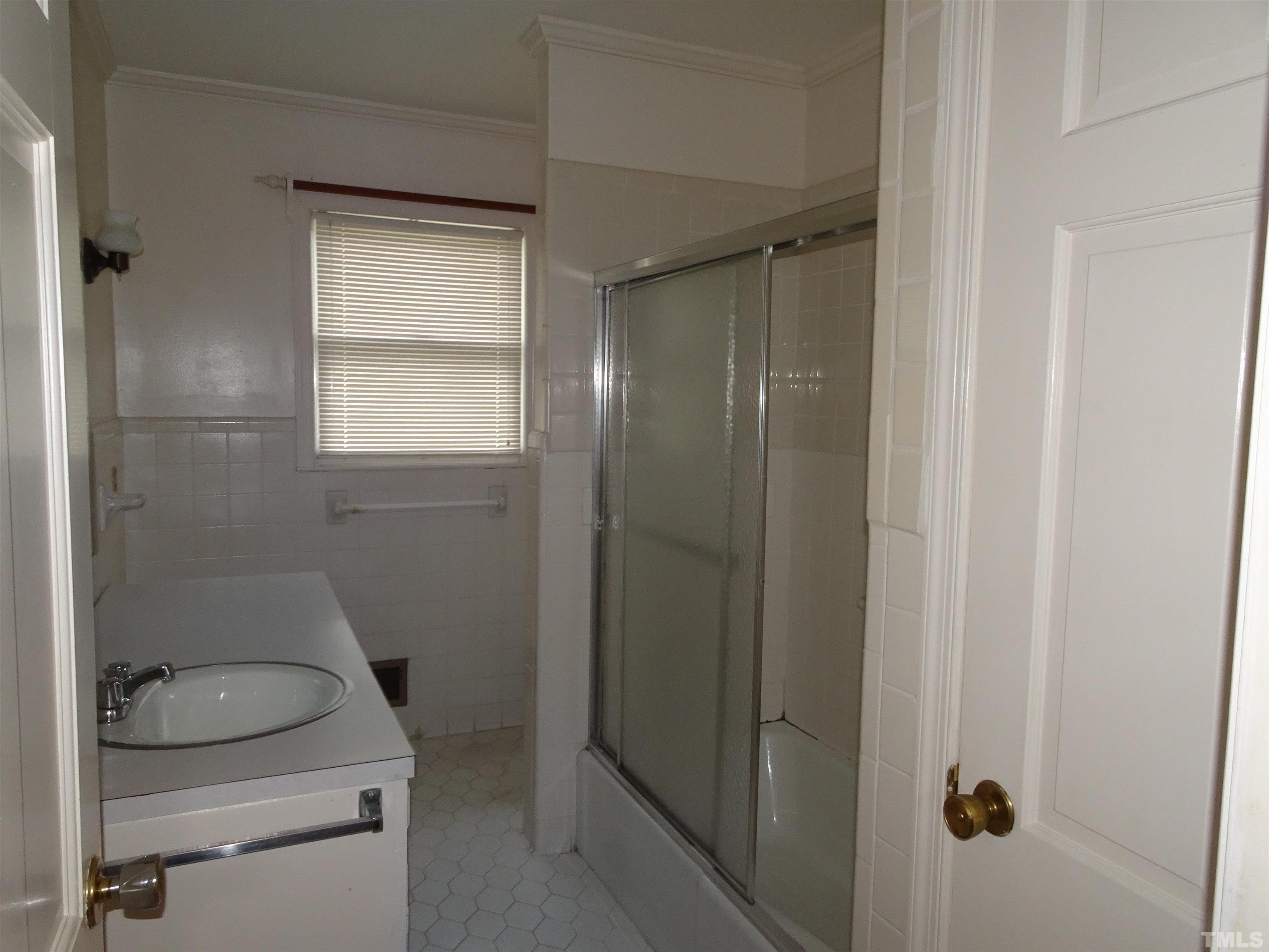 1619 Warrenton Road Henderson, NC 27537 - Photo 19 of 51 The hall bath has tub with doors and a large single vanity.