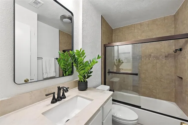 a bathroom with a sink a toilet a mirror and shower