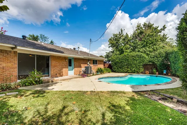 a view of a house with backyard and sitting area