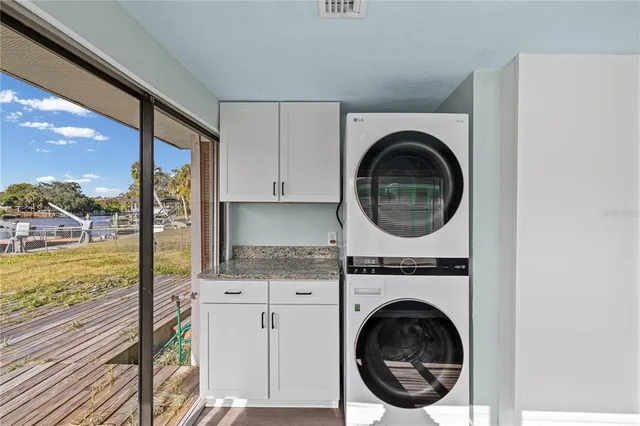 a view of a kitchen with a sink and a washer dryer