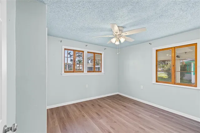 an empty room with a window and a ceiling fan