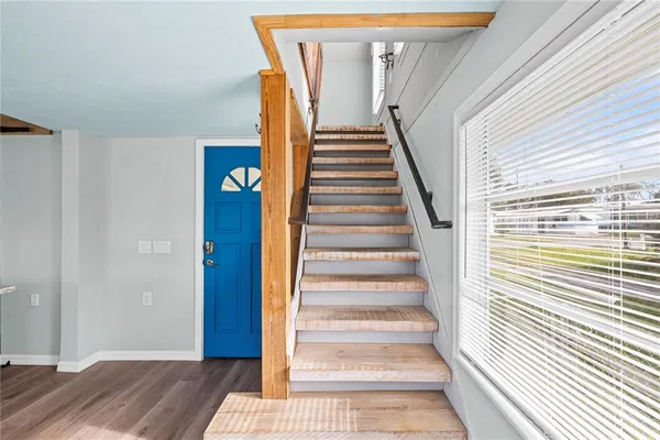 a view of a bedroom with wooden floor and stairs