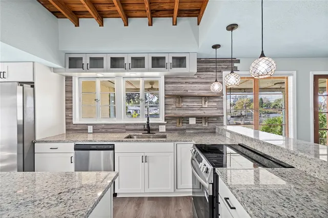 a kitchen with kitchen island granite countertop a sink and cabinets