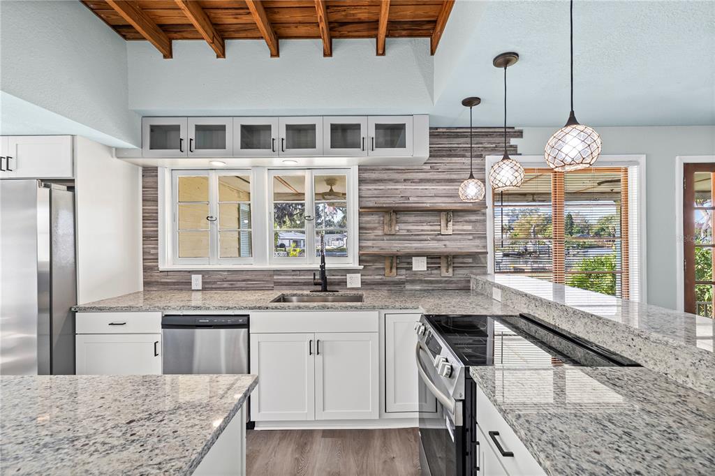 5642 Riverview Drive New Port Richey, FL 34652 - Photo 4 of 41 a kitchen with kitchen island granite countertop a sink and cabinets