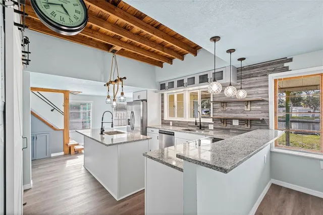 a kitchen with a sink and a wooden floor