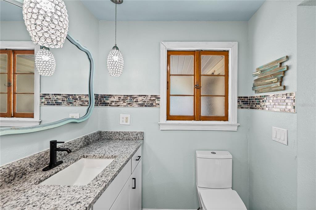 5642 Riverview Drive New Port Richey, FL 34652 - Photo 10 of 41 a bathroom with a granite countertop sink a toilet and a mirror