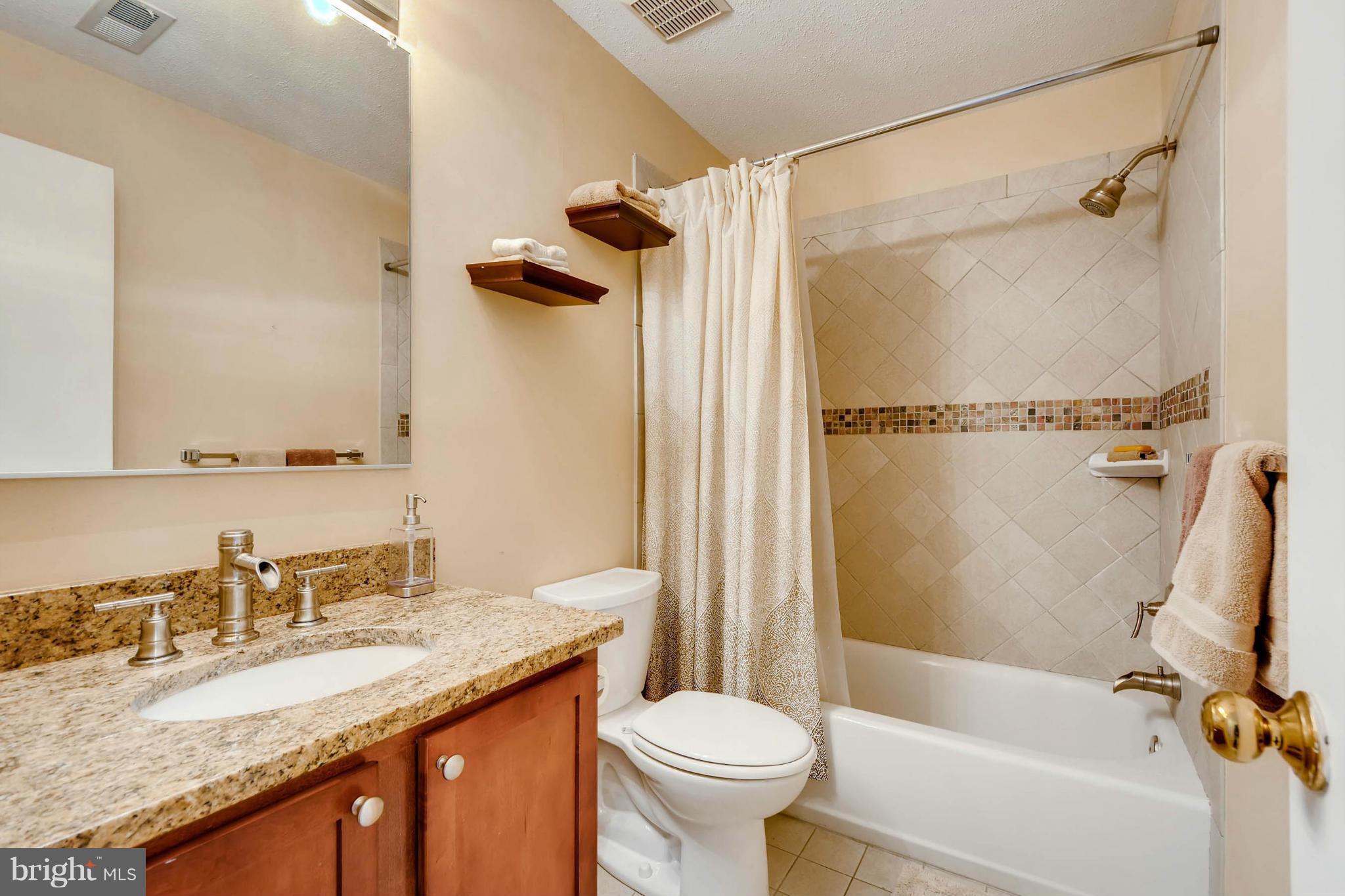 620 Charles Street, Unit R33 Baltimore, MD 21230 - Photo 16 of 27 a bathroom with a granite countertop sink toilet and shower