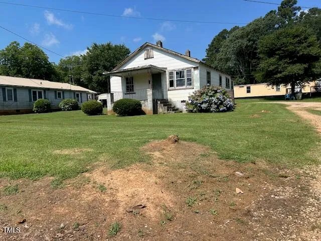 a front view of a house with a yard and trees