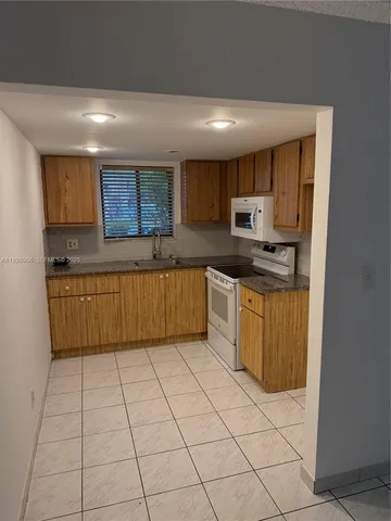 a kitchen with stainless steel appliances granite countertop a stove top oven a sink a counter top space and cabinets