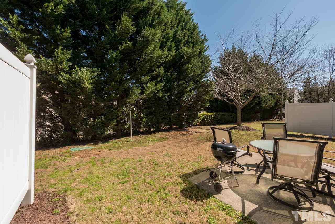 8214 Beaded Stone Street Raleigh, NC 27613 - Photo 22 of 25 a view of backyard with table and chairs and couches