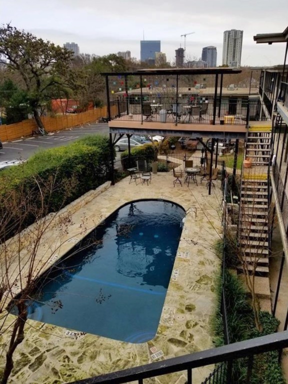 1202 Newning Avenue, Unit 113 Austin, TX 78704 - Photo 13 of 13 Community pool with a patio area, a city view, and stairway