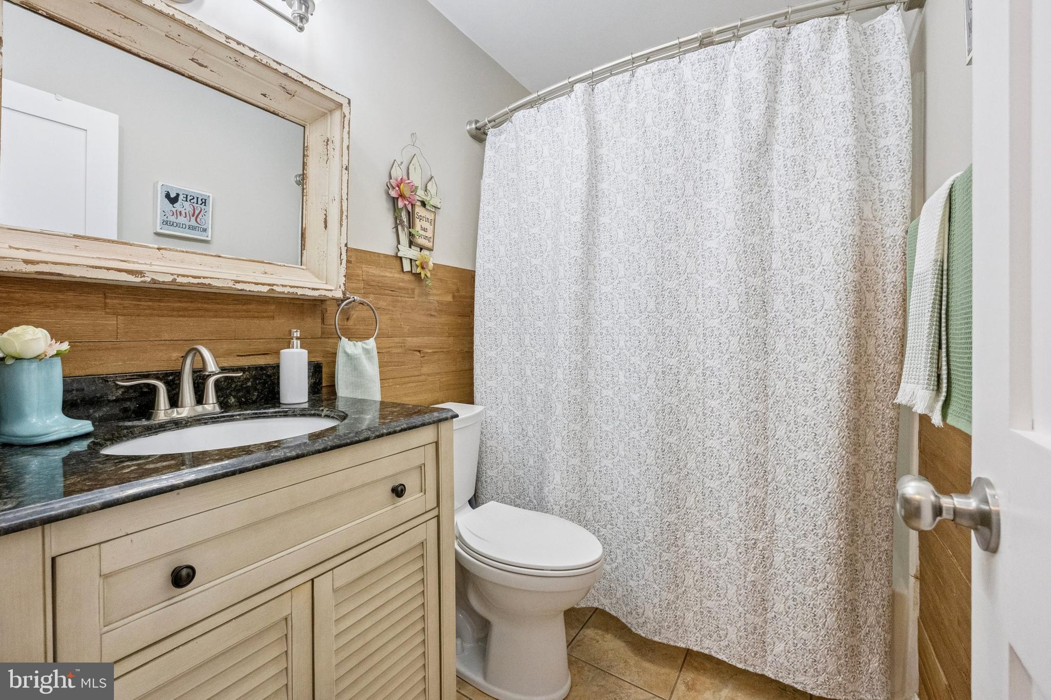 984 Rill Road Reading, PA 19606 - Photo 16 of 26 a bathroom with a granite countertop sink a toilet and a mirror