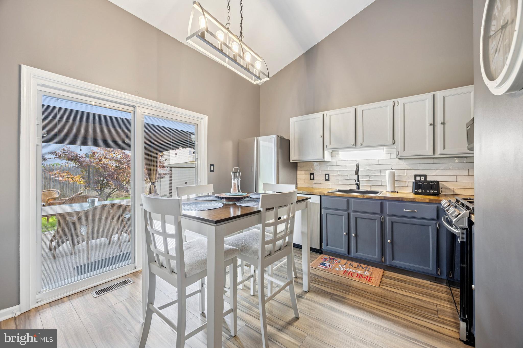 984 Rill Road Reading, PA 19606 - Photo 6 of 26 a kitchen with stainless steel appliances granite countertop a stove a refrigerator a sink a dining table and chairs with wooden floor