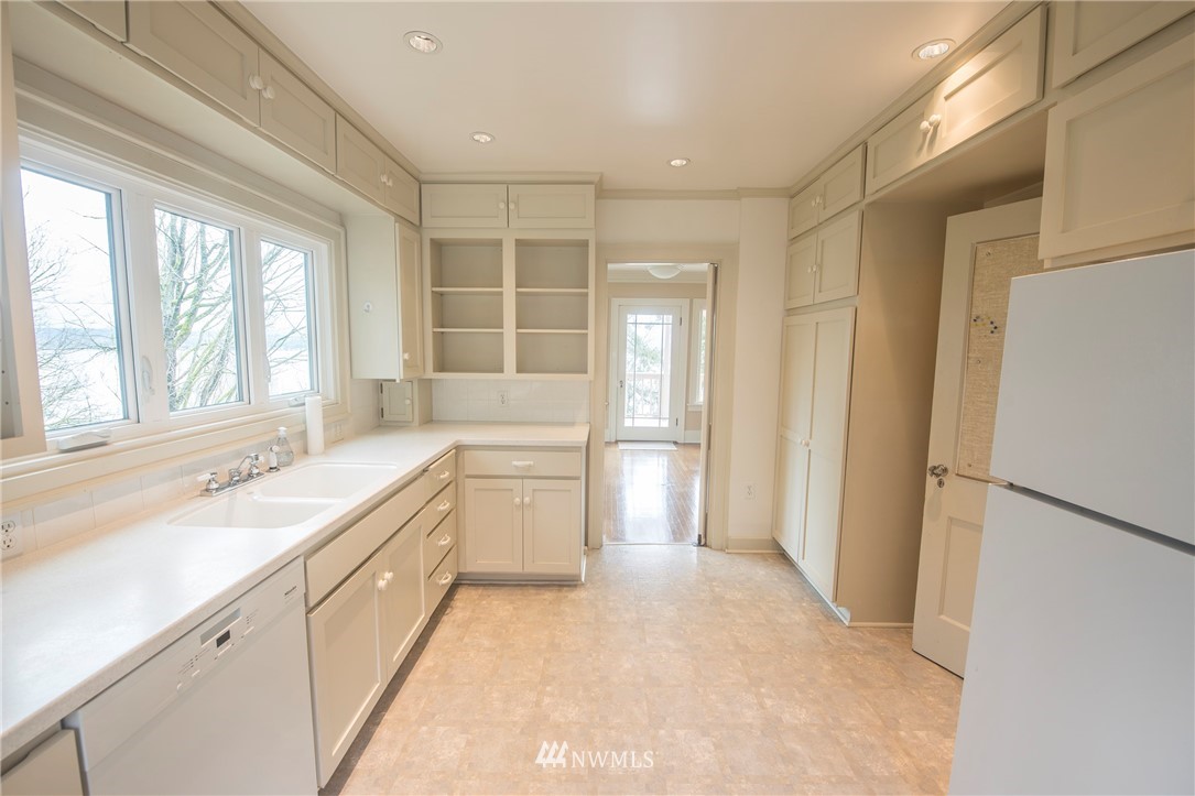 412 36th Avenue Seattle, WA 98122 - Photo 7 of 25 a large white kitchen with a sink and a large window